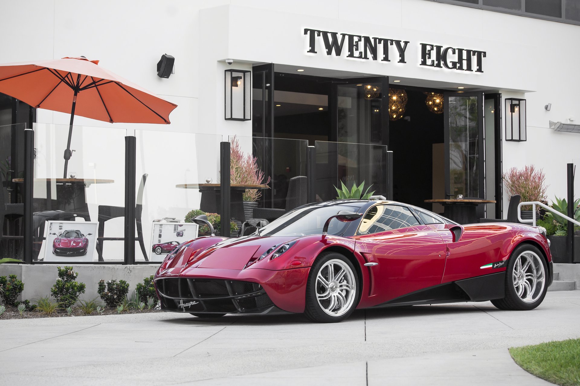 A red Pagani Huayra supercar is parked outside a building labeled TWENTY EIGHT, presented as a 4K Ultra HD PC desktop wallpaper and background.