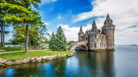 Boldt Castle on Heart Island, a man-made landmark in New York, USA, surrounded by water and greenery under a bright blue sky, captured in HD for a desktop wallpaper.
