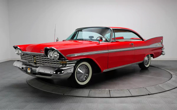 HD desktop wallpaper featuring a classic red Plymouth Sport Fury vehicle with chrome details against a neutral studio background.