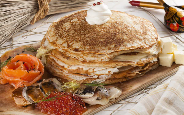 HD desktop wallpaper of a still life featuring a stack of crêpes topped with cream, accompanied by caviar, smoked fish, and small cubes of butter.