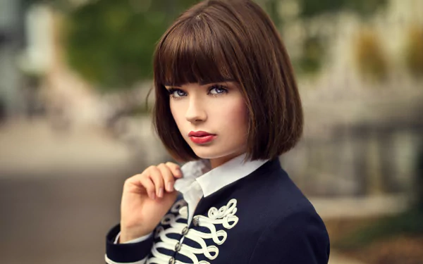 HD desktop wallpaper of Marie Grippon, a brunette model with short hair, blue eyes, and bold lipstick, dressed in a stylish jacket with decorative buttons.