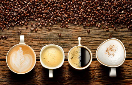 HD desktop wallpaper featuring a still life of coffee beans and four cups of different coffee styles placed on a wooden surface.