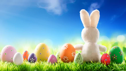 8K Ultra HD Easter-themed desktop wallpaper featuring a fluffy stuffed bunny facing colorful decorated Easter eggs on vibrant green grass under a bright blue sky.