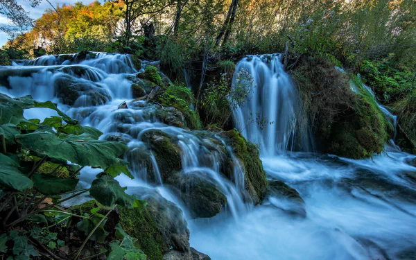 HD desktop wallpaper showcasing the vibrant waterfalls and lush greenery of Plitvice Lake National Park, highlighting its stunning natural beauty and flowing water.