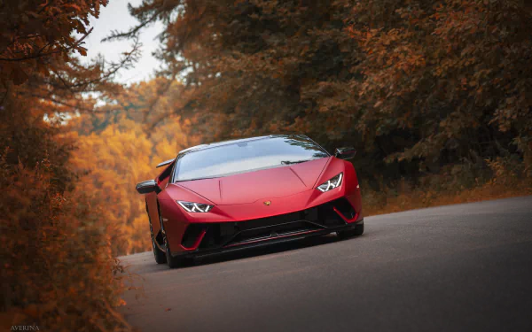 Red Lamborghini Huracan Performante supercar on a curving road surrounded by autumn trees, featured as an HD PC desktop wallpaper and background.