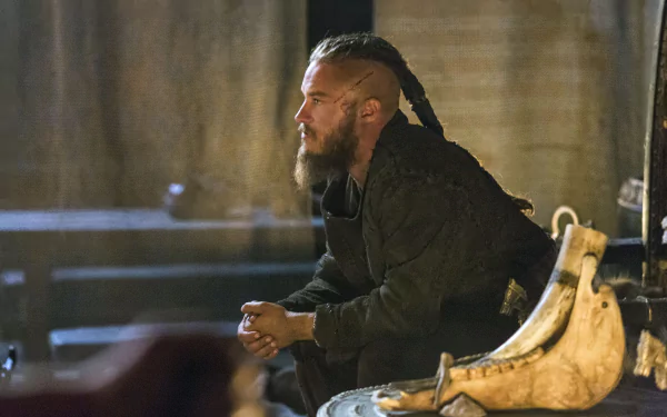 HD PC desktop wallpaper featuring a scene from the TV show Vikings (2013) with a bearded man in dark clothing sitting thoughtfully indoors.