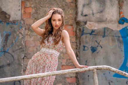 HD PC desktop wallpaper: brunette woman model in a floral dress with lipstick poses on a weathered railing against a graffiti-strewn wall.