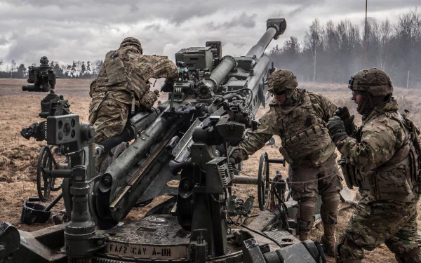 Soldiers operating heavy artillery in a military field, captured in a high-definition PC desktop wallpaper showcasing tactical readiness under a cloudy sky.