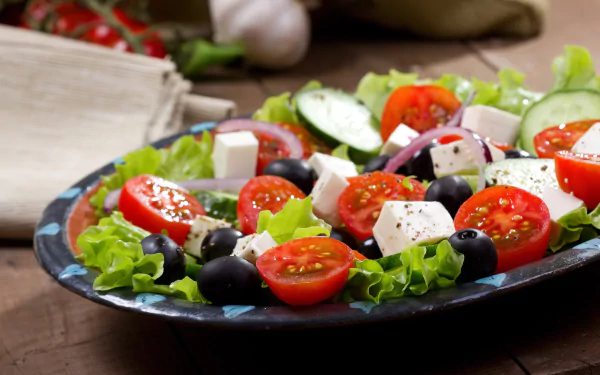 A vibrant salad of olives, cherry tomatoes, and cheese cubes on fresh lettuce, captured in HD for a crisp PC desktop wallpaper and background.