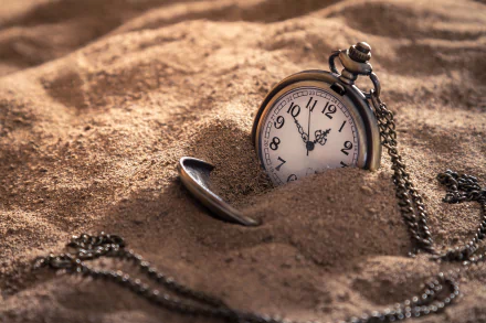 A high-definition desktop wallpaper featuring a pocket watch partially buried in the sand with its chain draped around, representing the passage of time.