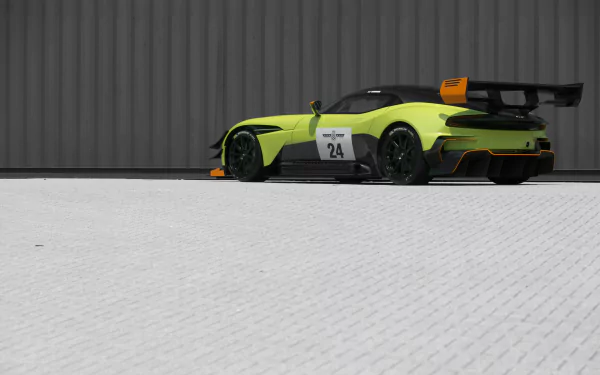 Aston Martin Vulcan AMR Pro in lime and black, rear three-quarter view parked before a corrugated wall — 5K Ultra HD PC desktop wallpaper/background.