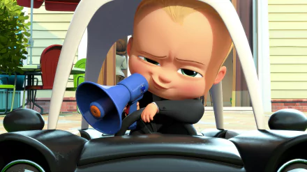 HD desktop wallpaper featuring Theodore Templeton, also known as The Boss Baby, from the movie The Boss Baby, sitting in a toy car and speaking into a blue megaphone.