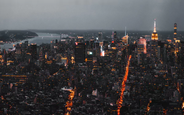 Nighttime HD desktop wallpaper of Manhattan skyline featuring the illuminated Empire State Building and city lights stretching through New York’s dense urban landscape.