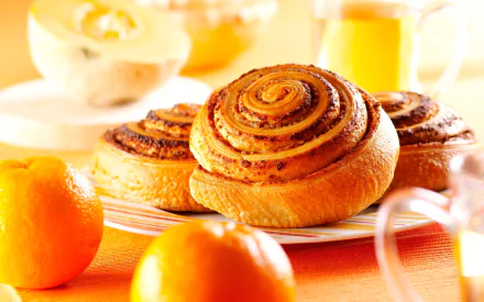 HD PC desktop wallpaper of viennoiserie breakfast food: golden cinnamon rolls on a plate with fresh oranges and a glass of juice.