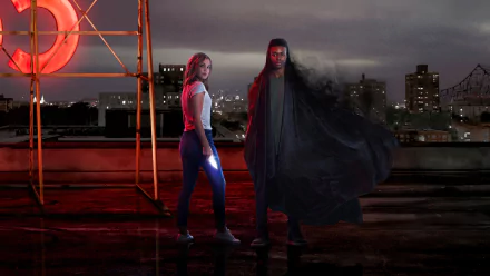 HD PC desktop wallpaper from the TV show Cloak & Dagger, featuring the two main characters standing on a rooftop with a cityscape at dusk.