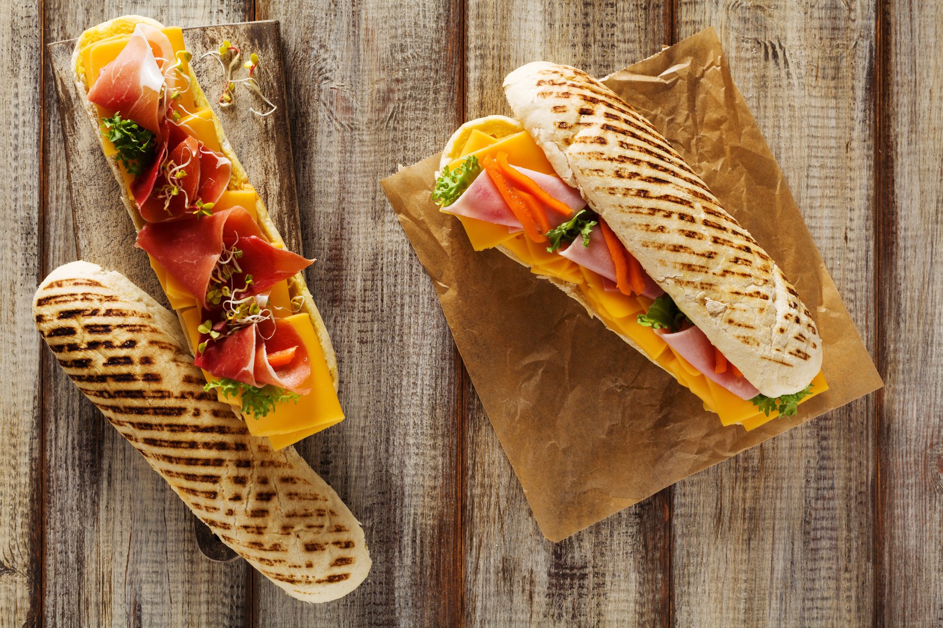 Close-up 4K Ultra HD wallpaper of two fresh sandwiches with grilled bread, layered with cheese, smoked salmon, and greens, styled as a vibrant food still life.