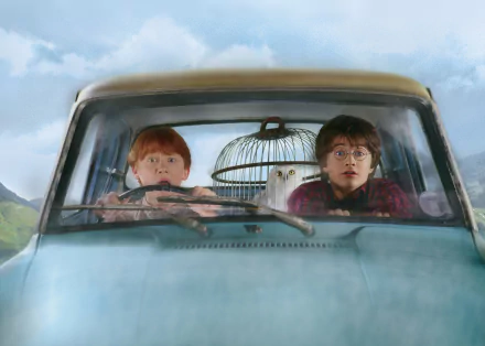 Rupert Grint as Ron Weasley and Daniel Radcliffe as Harry Potter are shown inside a car, with an owl in a cage, from Harry Potter and the Chamber of Secrets. HD desktop wallpaper.