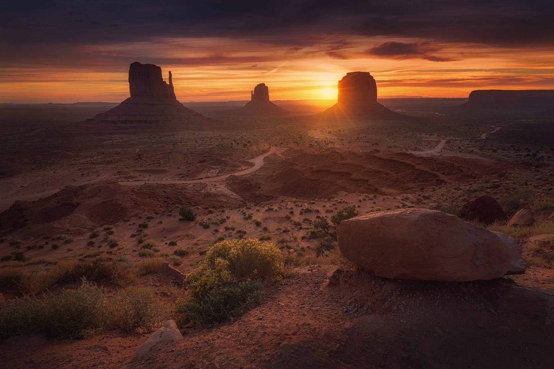 A stunning sunrise illuminates the iconic rock formations of Monument Valley, showcasing the beauty of the desert landscape in this breathtaking HD wallpaper.