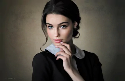 HD desktop wallpaper featuring a model with striking blue eyes and black hair, posing thoughtfully against a muted background.