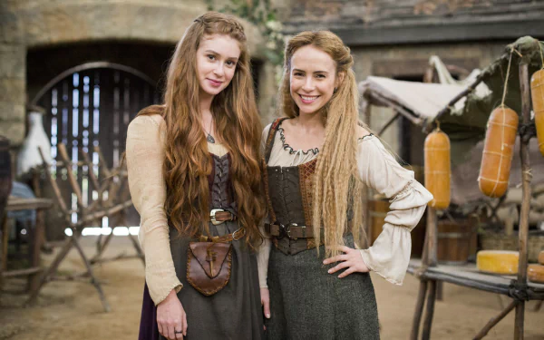 HD desktop wallpaper from Deus Salve o Rei featuring two smiling characters in a medieval set.