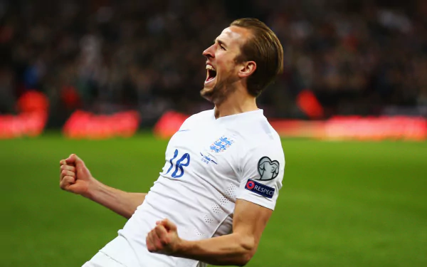 HD desktop wallpaper featuring English soccer player Harry Kane celebrating passionately during a match.
