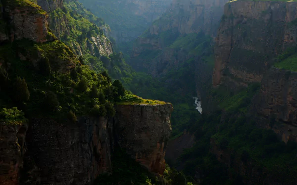 HD desktop wallpaper of a lush forested cliff landscape in Brazil, with massive mountains and a river carving through the deep valley below.