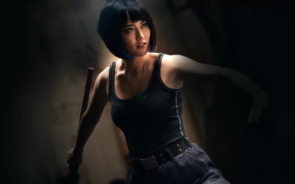 HD desktop wallpaper featuring a focused individual from Pacific Rim, resembling Rinko Kikuchi, set against a shadowy backdrop.