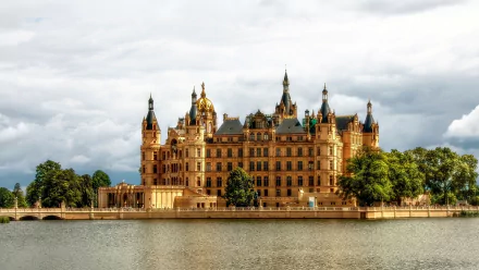 HD desktop wallpaper of Schwerin Palace in Germany, showcasing its intricate architectural details and grand facade reflected in the calm water.