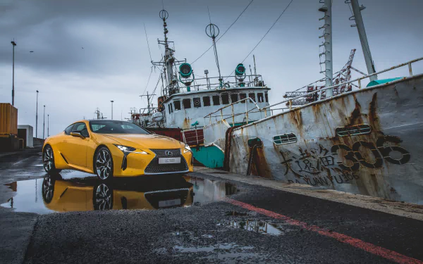 Yellow Lexus LC 500 grand tourer parked beside a weathered ship on a wet dock, captured in stunning 4K Ultra HD for a dynamic PC desktop background.