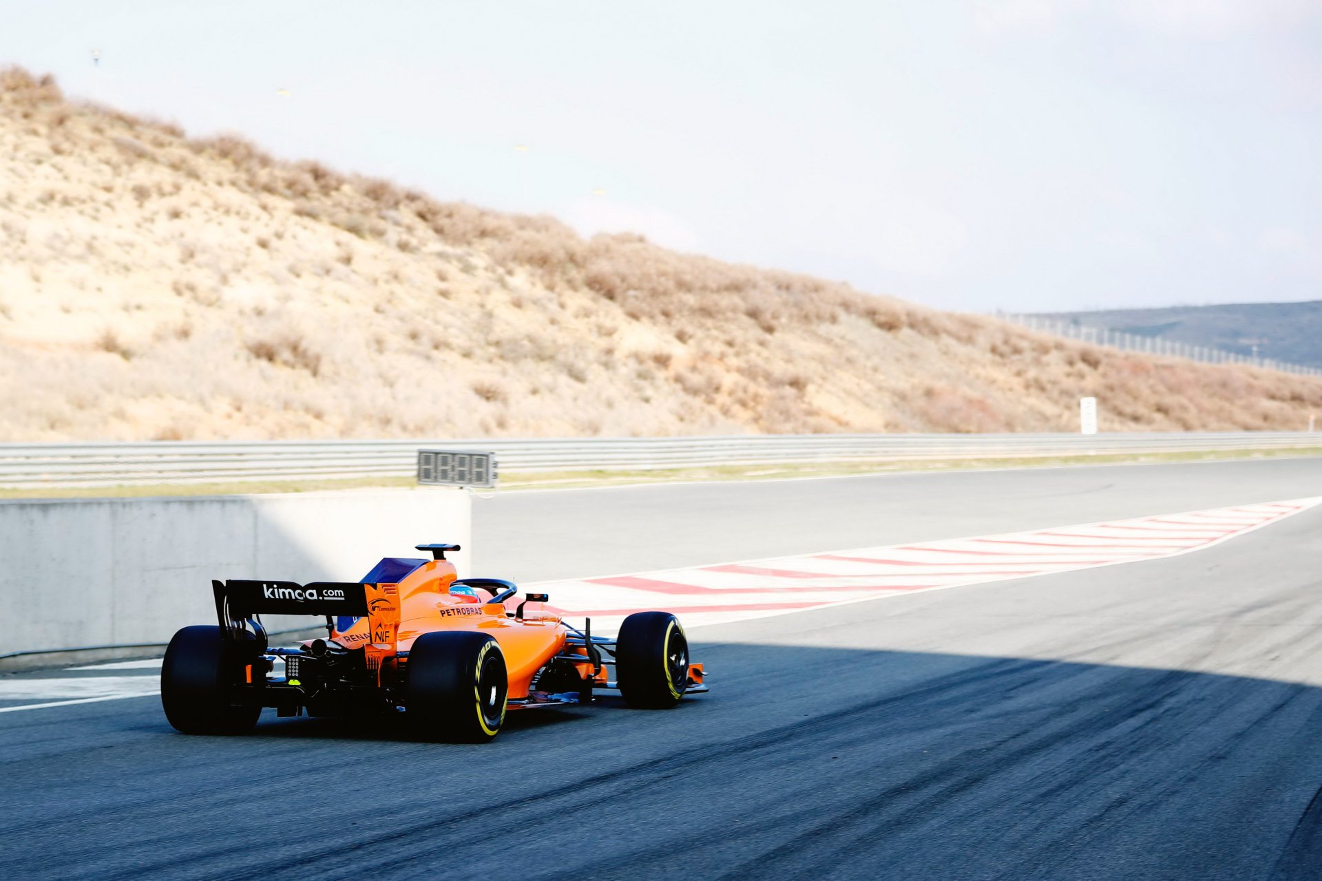 McLaren MCL33 F1 car racing on a sunlit track, showcasing vibrant orange and blue colors in a 4K Ultra HD PC desktop wallpaper and background.