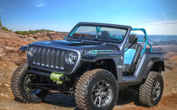 HD desktop wallpaper featuring a rugged Jeep 4-speed vehicle with off-road tires, set against a clear blue sky and rocky desert landscape.