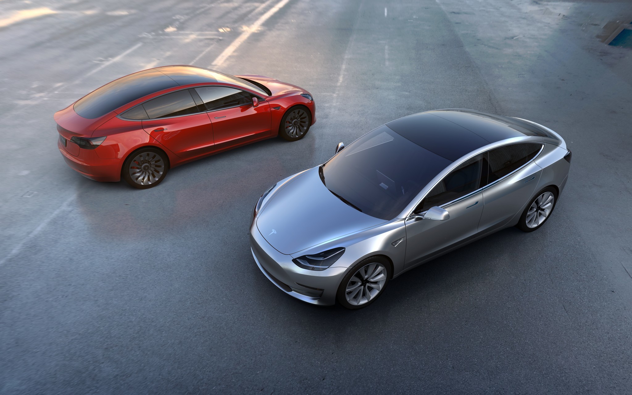 HD desktop wallpaper of a silver Tesla Model 3 alongside a red Tesla, representing Tesla Motors' electric vehicles.