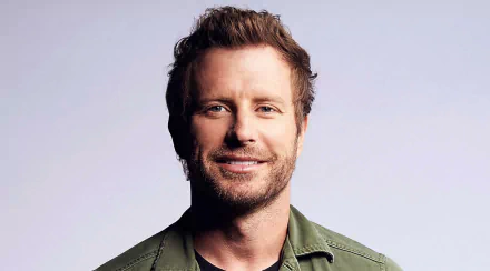 HD desktop wallpaper and background featuring a smiling man in a green shirt, providing a vibrant and personable ambiance.
