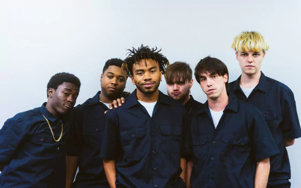 HD desktop wallpaper featuring members of BrockHampton in blue shirts against a white background.