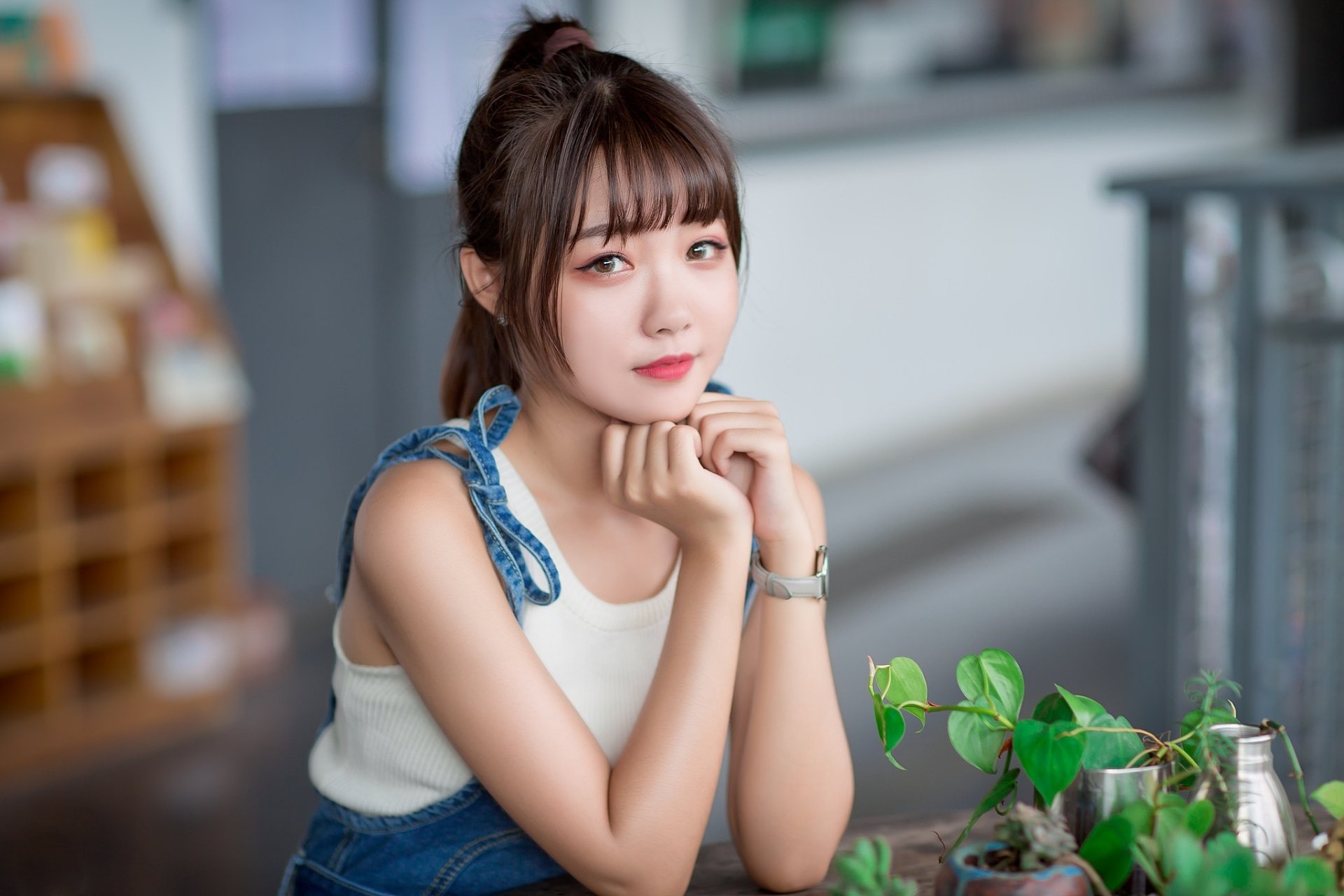 A stunning HD desktop wallpaper featuring an Asian woman with a brunette ponytail and lipstick, set against a background with a model-like pose and greenery elements.