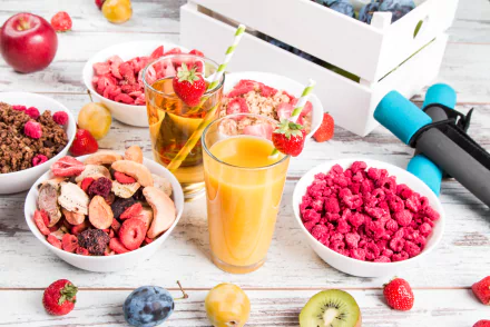 5K Ultra HD PC desktop background: still life breakfast scene with glasses of juice, bowls of cereal and berries, assorted fresh fruit on a white tabletop.