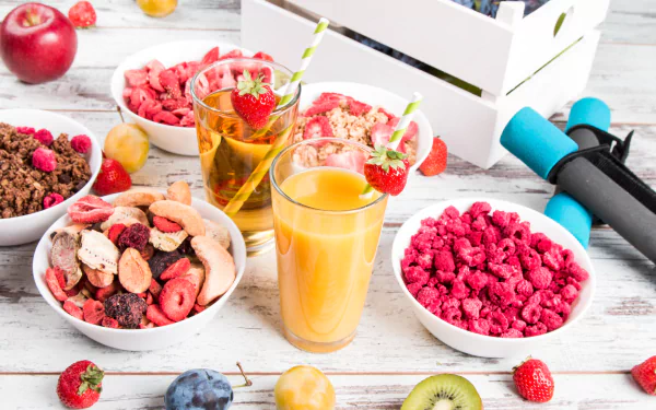 5K Ultra HD PC desktop background: still life breakfast scene with glasses of juice, bowls of cereal and berries, assorted fresh fruit on a white tabletop.
