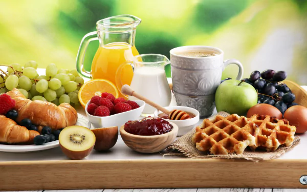 8K Ultra HD PC desktop wallpaper — breakfast still life with croissant, waffle, jam, honey, milk, juice, coffee and fresh fruit on a wooden tray.