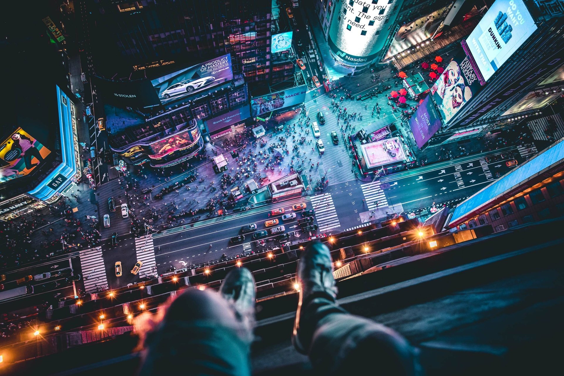 HD desktop wallpaper showing a bird’s-eye view of Manhattan’s bustling Times Square at night with bright lights, crowds, and city streets in New York.