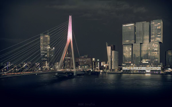 Night view of Rotterdam's illuminated Erasmus Bridge and modern architecture along the waterfront in the Netherlands, captured as an HD desktop wallpaper background.