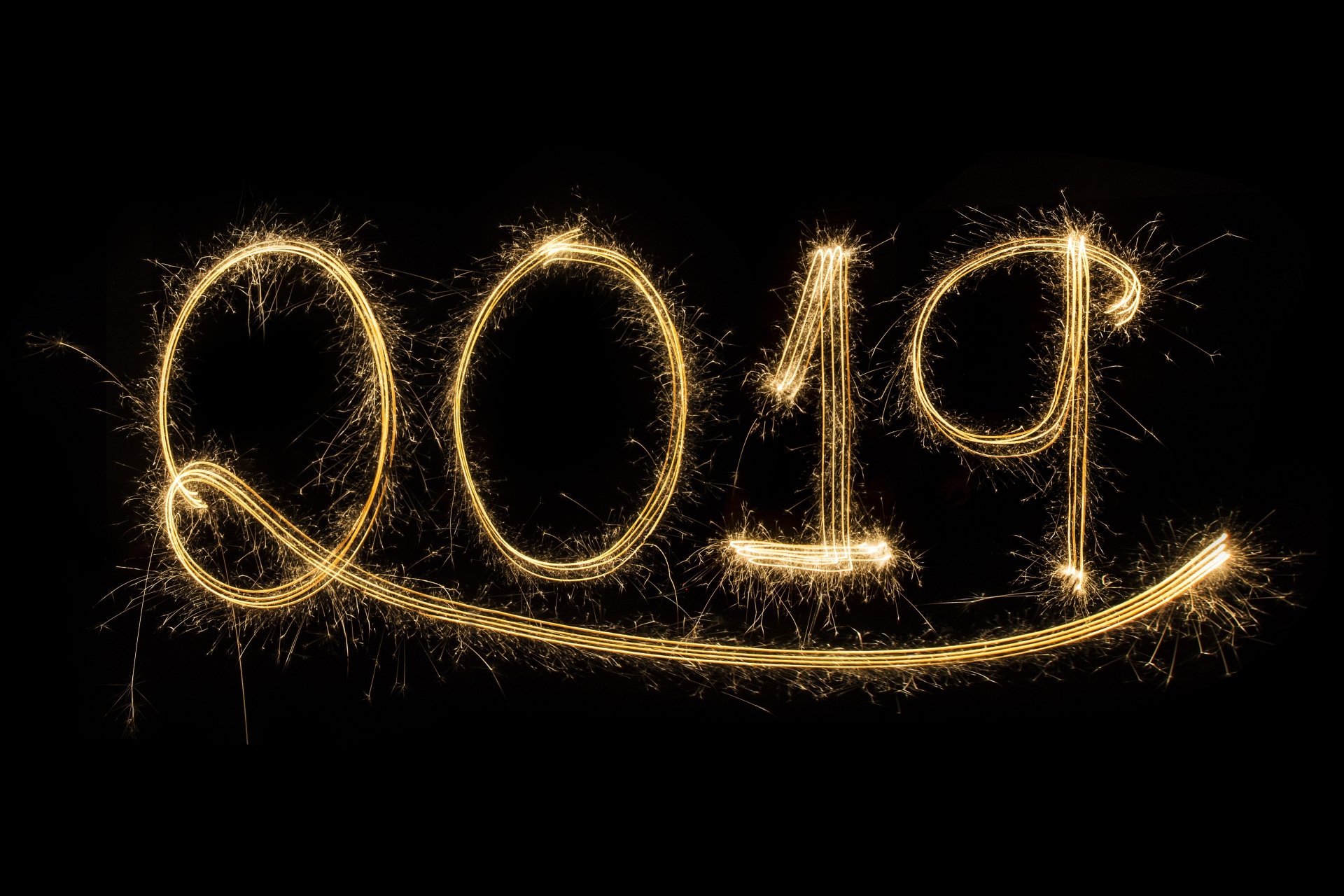 Golden sparkler spells 2019 with a sweeping underline on black — holiday New Year 2019 5K Ultra HD PC wallpaper