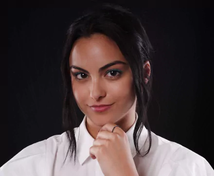 Close-up of American actress Camila Mendes smiling with brown eyes and black hair against a dark background, in 4K Ultra HD quality for desktop wallpaper.