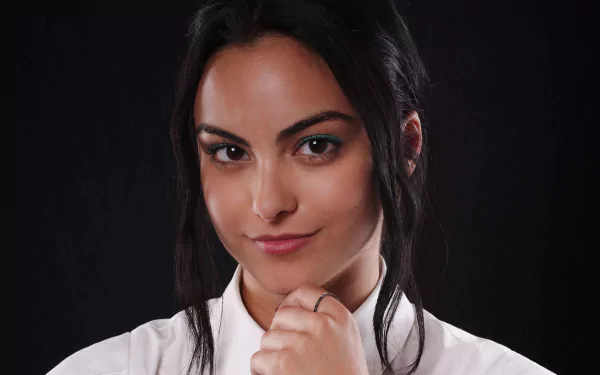 Close-up of American actress Camila Mendes smiling with brown eyes and black hair against a dark background, in 4K Ultra HD quality for desktop wallpaper.