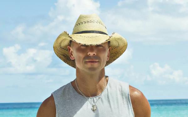 HD desktop wallpaper of a person wearing a straw hat with a beach background.