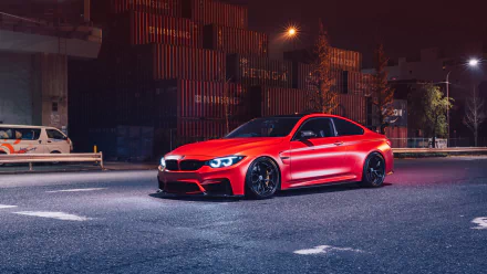 HD desktop wallpaper featuring a vibrant red BMW M3 parked on a dimly lit urban street at night.