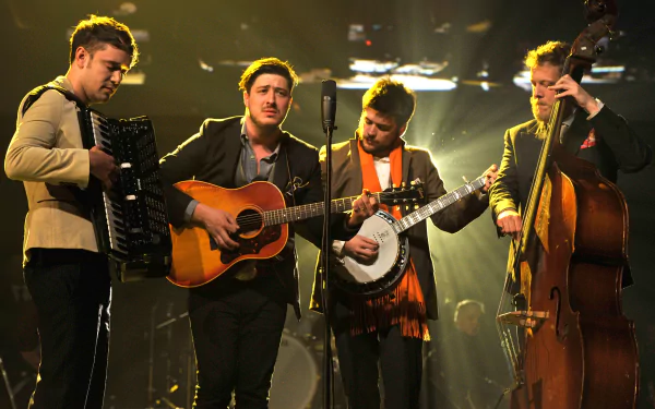 HD wallpaper of Mumford & Sons performing live with instruments under stage lighting.
