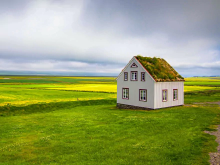 A man-made house with a grass-covered roof stands alone in a vast green field under a cloudy sky, captured in an HD PC desktop wallpaper and background.