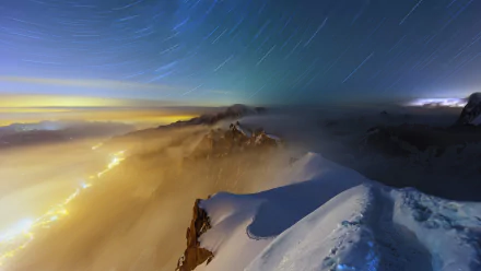 A breathtaking night scene capturing a snow-covered mountain under a star trail sky, with fog enveloping the horizon, showcasing the serene beauty of nature.