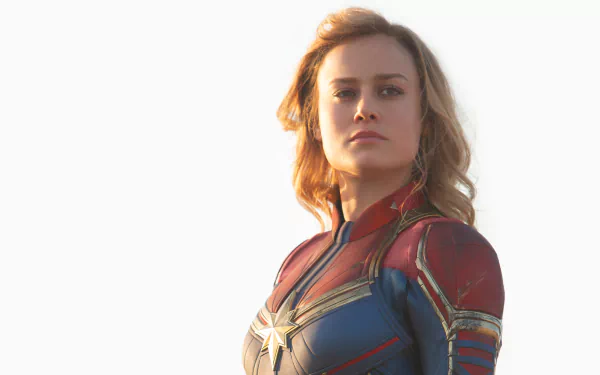 HD wallpaper of Brie Larson as Captain Marvel, showcasing the character's iconic costume and determined expression against a light background.
