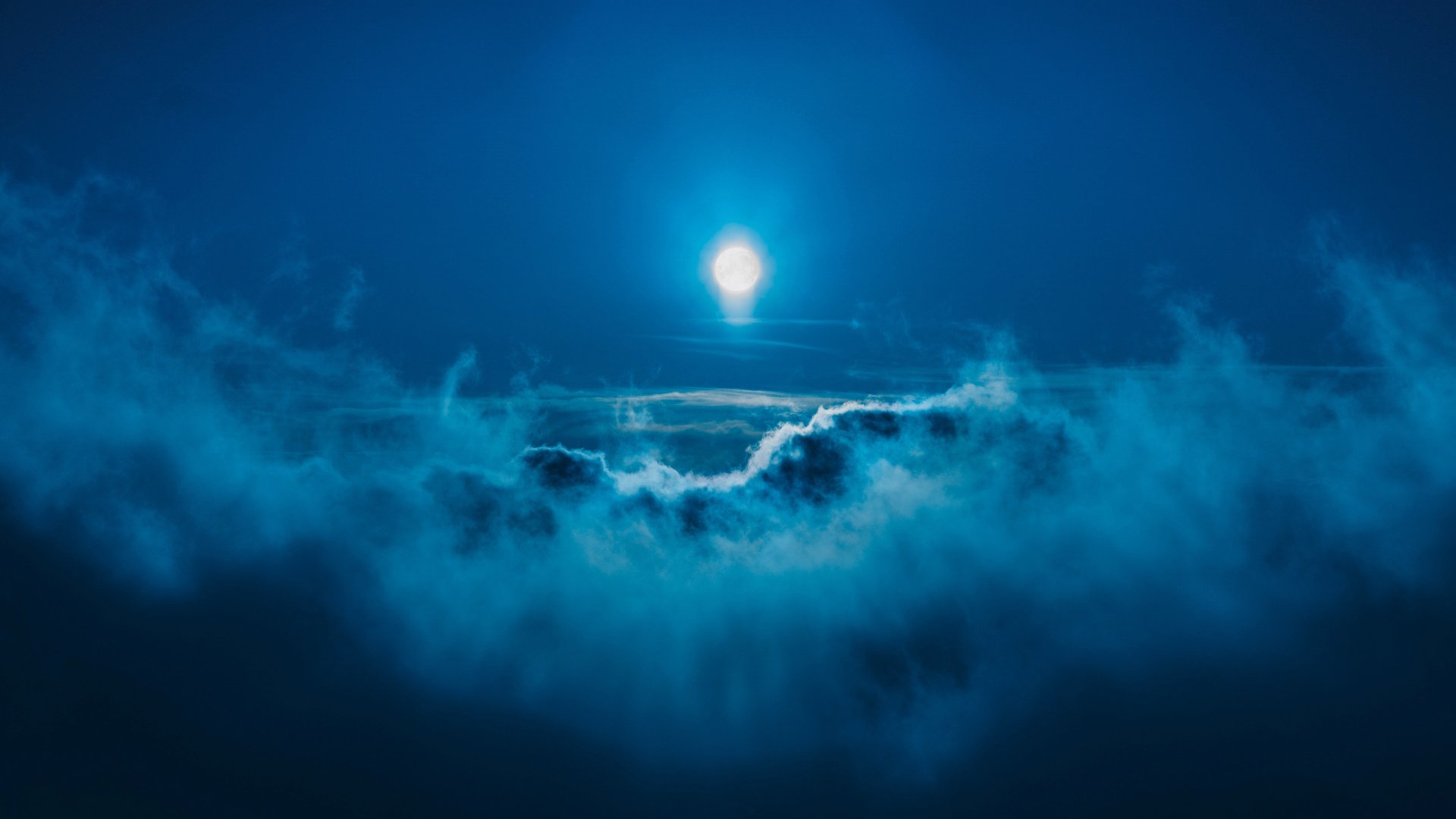 HD desktop wallpaper: A serene night scene of the moon illuminating a sky filled with wispy clouds, highlighting nature's tranquil beauty.